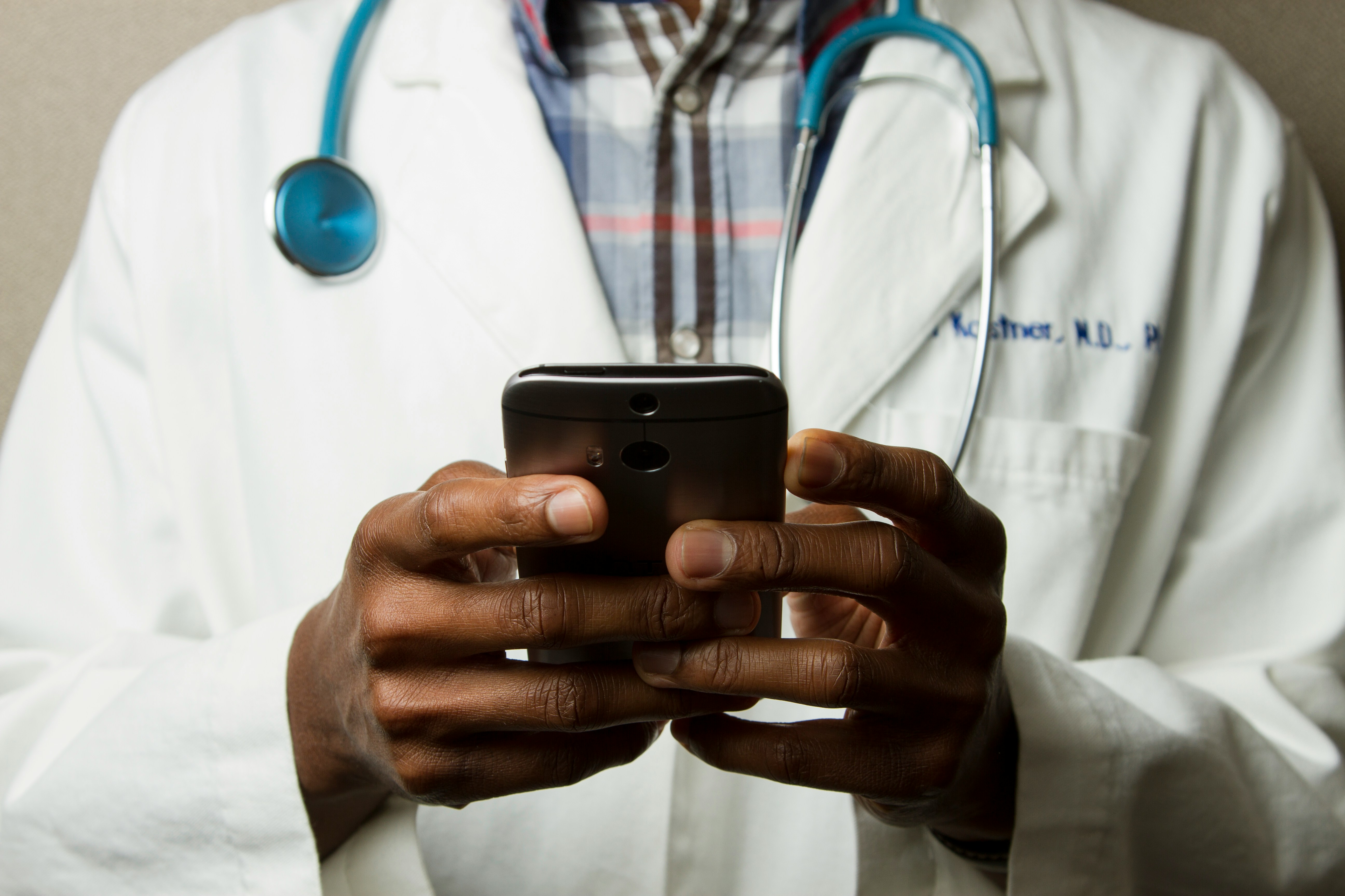 Healthcare professional using medical app on smartphone for patient care